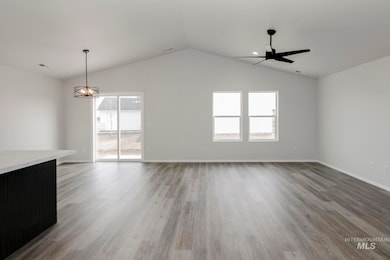 Unfurnished room with light wood-style flooring, lofted ceiling, and a chandelier