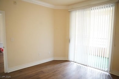 Spare room featuring wood finished floors, baseboa