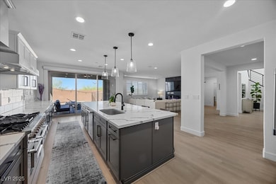 Kitchen with a sink, wall chimney range hood, rang