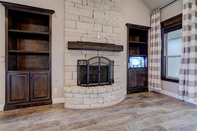 living room with a stone fireplace and vaulted cei