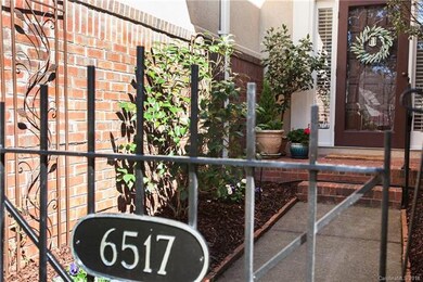 Gated front court yard full of beautiful flowers a