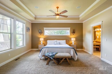Bedroom featuring a tray ceiling, multiple windows, carpet, and crown molding