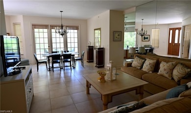 Tiled living room with a notable chandelier
