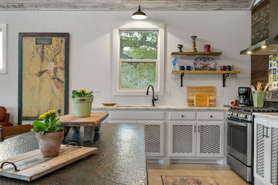 Kitchen featuring stainless steel gas range, a si