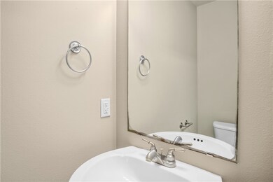 Bathroom featuring a textured wall and a sink