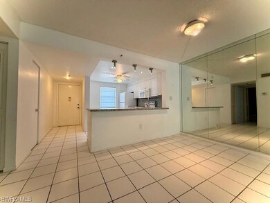 Kitchen featuring white appliances, ceiling fan, light tile patterned floors, and white cabinetry