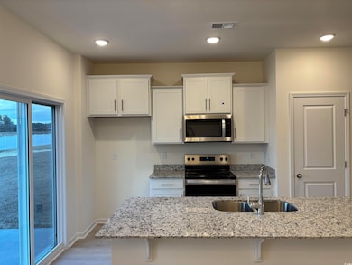 Kitchen featuring light stone countertops, applian
