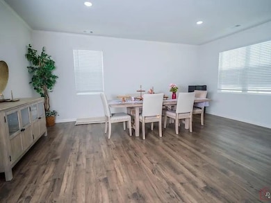 Dining space with crown molding, dark wood-type flooring, and recessed lighting