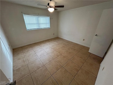 Unfurnished room featuring ceiling fan, light tile