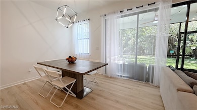 Dining area with light wood-style flooring and baseboards