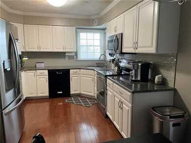 Updated Kitchen featuring crown molding, granite counter tops hardwood flooring.