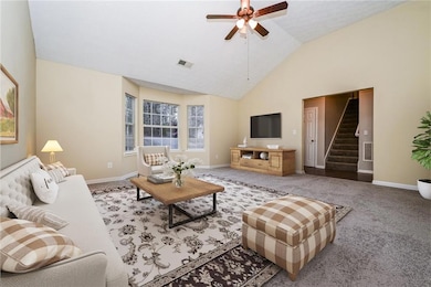 Living area featuring stairway, a ceiling fan, bas