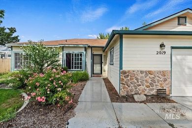 Property entrance featuring stone siding and an attached garage