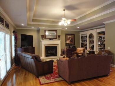 20x22 Living room with fireplace and hardwood flooring along with recessed lighting and built in shelving. 