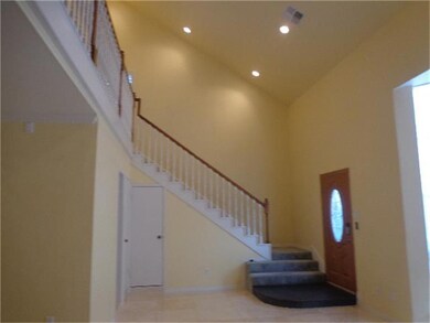 Staircase view includes front door, guest bath and balcony.