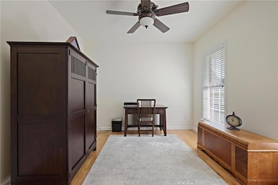 Home office with light wood finished floors and a ceiling fan