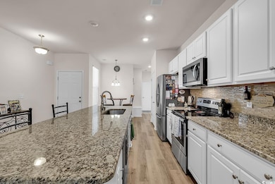 Kitchen with hanging light fixtures, white cabinet