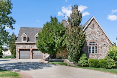 View of front of property with concrete driveway, stone siding, a shingled roof, and an attached garage