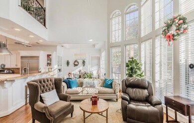Kitchen featuring white cabinetry, built in appliances, kitchen peninsula, light stone counters, and light hardwood / wood-style floors