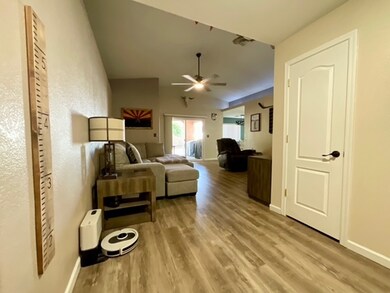Living room with ceiling fan, wood finished floors