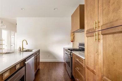 Kitchen featuring appliances with stainless steel finishes, sink, backsplash, custom exhaust hood, and hanging light fixtures