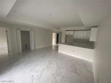 Unfurnished living room with a tray ceiling and light tile flooring