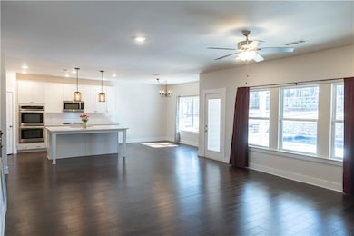 Unfurnished living room featuring dark hardwood / 
