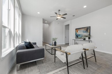 Living room featuring ceiling fan, baseboards, vi