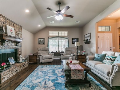 Living area with lofted ceiling, dark wood-type flooring, a fireplace, a ceiling fan, and recessed lighting
