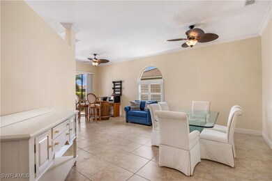Tiled dining space with ceiling fan and crown mold