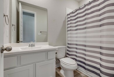 Full bath with curtained shower, toilet, wood fin