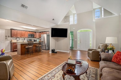 THE FOYER IS OPEN TO THE LIVING ROOM AND KITCHEN. LOTS OF NATURAL LIGHT COMES IN THROUGH ALL THE WINDOWS.