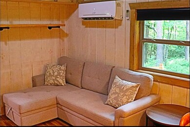 Sitting room with a wall mounted air conditioner and wooden walls