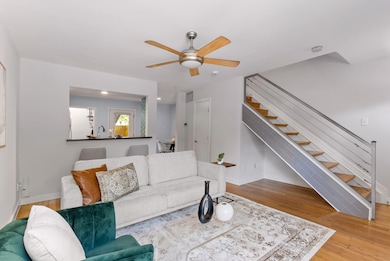 Living room with baseboards, a ceiling fan, wood 