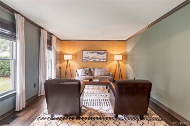 Hardwood floored living room with crown molding an