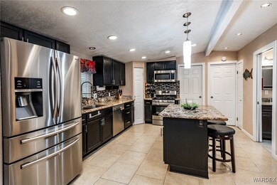 Kitchen with a sink, dark cabinetry, backsplash, a