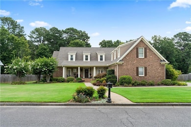 New england style home featuring covered porch and brick siding