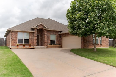 View of front of home with brick siding, driveway, roof with shingles, and an attached garage