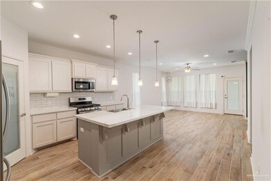Kitchen featuring appliances with stainless steel finishes, a sink, backsplash, open floor plan, and ceiling fan