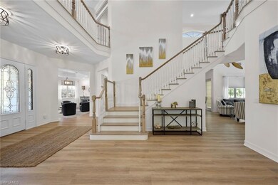 Entryway featuring stairway, a high ceiling, wood finished floors, baseboards, and ceiling fan
