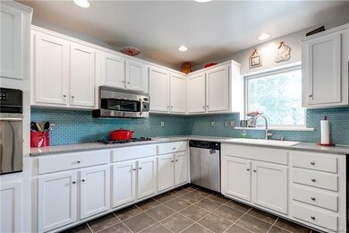 Additional view of kitchen with wall oven at left.