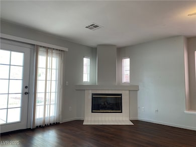 Unfurnished living room featuring dark wood-style flooring and a fireplace