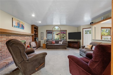 Living area with carpet, a brick fireplace, and built in shelves