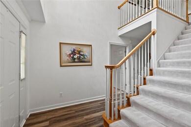 Stairs with wood finished floors and a towering ceiling