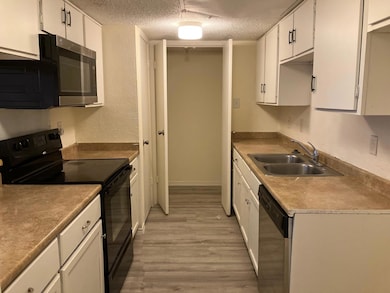 Kitchen with white cabinets, sink, appliances with
