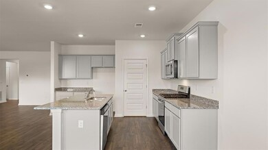 Kitchen with gray cabinetry, stainless steel appli