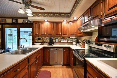 Kitchen featuring stainless steel appliances, a sink, wooden ceiling, light wood-style floors, and ceiling fan