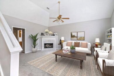 Carpeted living room featuring ceiling fan, lofted