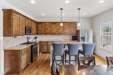 Kitchen with stainless steel appliances, light woo