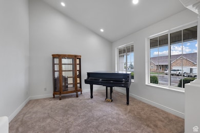 Sitting room with carpet floors, recessed lighting, and high vaulted ceiling
